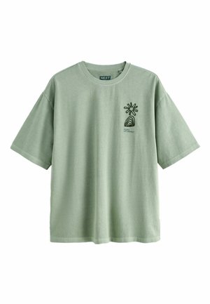 T-shirt vert clair à manches courtes avec un design abstrait noir de soleil et arc-en-ciel, et le texte "Bilbao Art District" sur la poitrine gauche.