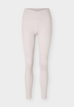 Svetlo bež hlačne nogavice z visokim pasom brez šivov z detajlom preklopnega pasu, prikazane ravno na belem ozadju.