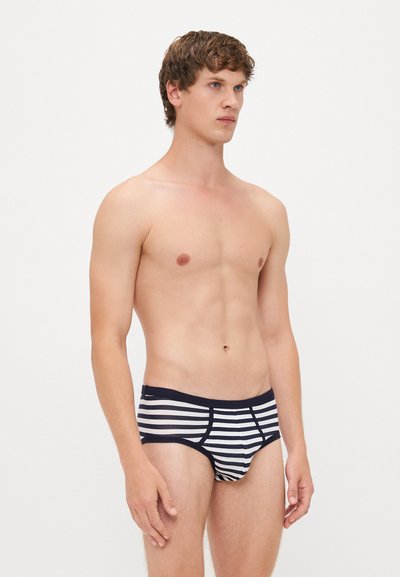 Gestreifte Badehose in Marineblau und Weiß. Weiches, elastisches Material mit passgenauer Form. Verfügt über einen kontrastierenden Bund und eine glatte Textur.