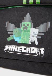 Zaino nero con arte pixel di personaggi: un Creeper verde, uno zombie azzurro e uno scheletro bianco; logo "MINECRAFT" in bianco.