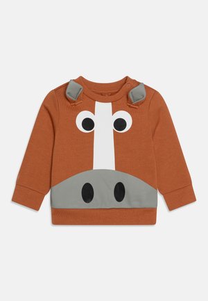 Sweat-shirt couleur rouille pour tout-petit avec motif visage d’animal, grands yeux, museau gris et deux oreilles en tissu doux aux épaules.