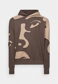Felpa marrone con cappuccio caratterizzata da un design grafico di volto in beige, con effetto usurato ai bordi e un aspetto testurizzato. Polsini e orlo a coste.