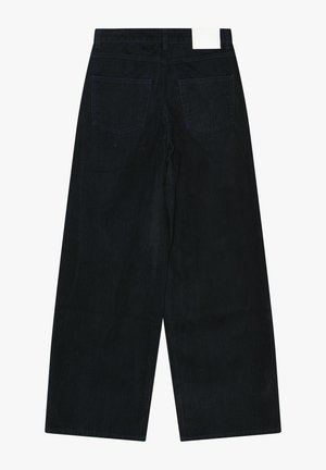 Sorte bredbenede jeans med en let struktureret stof, der har to baglommer og et hvidt mærke i taljen.