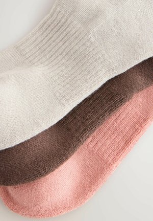 Drei Sockensets übereinander gestapelt: hellbeige, dunkelbraun und sanft rosa. Jedes Paar hat ein strukturiertes Strickmuster und verstärkte Fersen.