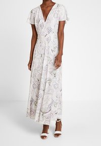 Maxi dress in light pastel colors with a paisley pattern, v-neckline, and flutter sleeves. Made of a lightweight, textured fabric.