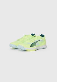 Baskets de sport jaune néon avec une tige en maille texturée, des accents verts et une semelle en caoutchouc bleu clair ; elles présentent un design moderne et épuré.