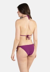 Bikini violet avec des bretelles réglables et des liens sur les côtés. Matériau lisse, couverture minimale et texture douce, mettant en avant un design uni.
