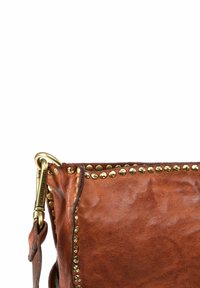 Borsa a mano in pelle marrone con borchie dorate lungo la parte superiore, caratterizzata da una superficie testurizzata e una clip in ottone per il fissaggio.