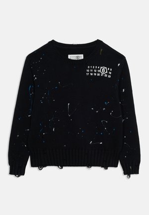 Mustast kootud kampsun kulunud äärtega, värvilaigu mustritega ja valge numbriprindiga vasaku õla lähedal.