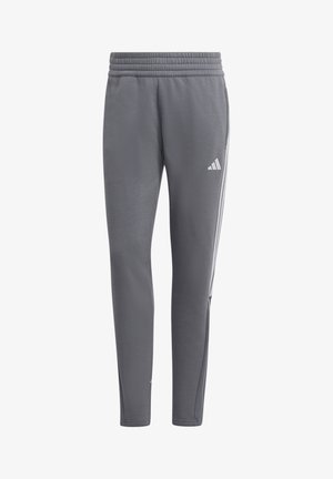 Szare sportowe spodnie z elastycznym pasem, bocznymi kieszeniami, zwężanymi nogawkami oraz białym logo Adidas i trzema paskami po obu stronach.