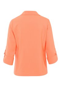 Koralen oranje jas met een kraag, driekwart opgerolde mouwen en een gestructureerde stof. Beschikt over zijsplitten voor gemakkelijke beweging.