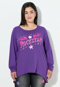 Lilla langærmet T-shirt med en "ROCKSTAR" grafik med vinger, stjerner og farverige detaljer. Blødt stof med et buet kantdesign.