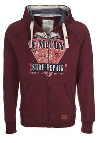 Sudadera con cremallera de color burdeos, fabricada en una mezcla de algodón. Presenta un estampado gráfico, dos bolsillos frontales y un cordón en contraste en la capucha.