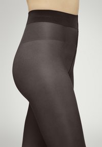 Collant neri trasparenti con una cintura larga, texture liscia e finitura semi-trasparente. Presentano un design avvolgente che si adatta al corpo.