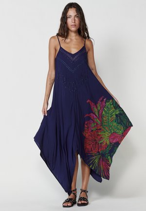 Marineblaues Maxikleid mit dünnen Trägern, verziert mit Perlen und einem bunten tropischen Blattdruck auf einer Seite. Weiches, fließendes Material.