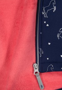 Fleece jacket in coral with a navy blue zipper section featuring white horse and heart patterns; soft texture and silver hardware detail.