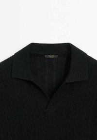 Maglione nero a maglia con texture a costine, dotato di colletto ripiegato e scollo a V. L'etichetta reca la scritta "Mommse Di."