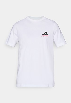 Weißes Baumwoll-T-Shirt mit einem schwarzen Drei-Streifen-Logo und 'Merkel' in Pink auf der linken Brust. Klassischer Rundhalsausschnitt und kurze Ärmel.