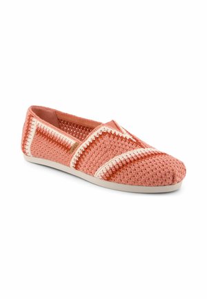 Korallenrosa gehäkelter Slipper mit weißen und rostfarbenen Zickzackstreifen und einer hellbeigen Sohle.