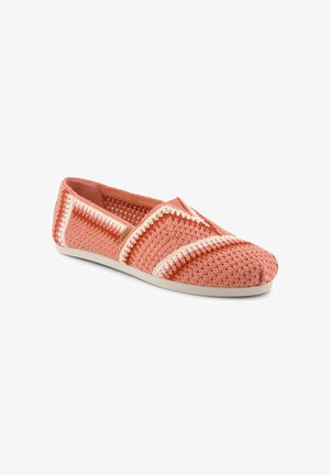 Korallenrosa gehäkelter Slipper mit weißen und rostfarbenen Zickzackstreifen und einer hellbeigen Sohle.