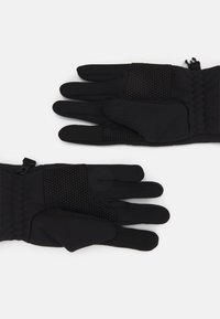 Black gloves made of soft material, featuring a textured grip area and a snug fit at the wrist, with two gloves displayed side by side.
