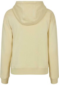 Sweat à capuche beige avec manches longues, poignets côtelés et ourlet côtelé, vu de dos sur fond blanc.
