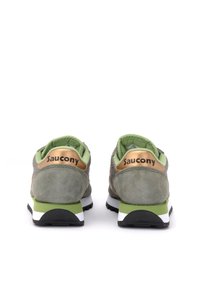 Grüne Wildleder-Sneaker mit goldenen Akzenten, weißer Mittelsohle und schwarzer Außensohle; auf der Ferse ist der Markenname "Saucony" zu sehen.
