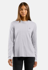 Langärmliges, hellgraues Hemd mit rundem Halsausschnitt und einer Brusttasche auf der linken Seite, die ein kleines gesticktes Logo zeigt. Weiche, strukturierte Baumwollmischung.