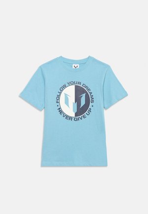 Világoskék rövid ujjú póló, rajta egy osztott kör logó és a körülötte lévő "KÖVESD ÁLMAIDAT, SOHA NE ADD FEL" szöveg.