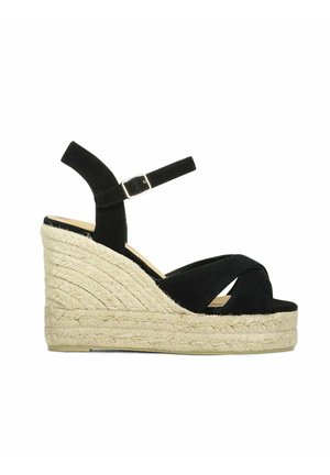 Zwarte suède sleehak sandaal met gevlochten jute plateauzool, enkelbandje en open teen.