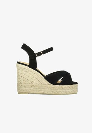 Zwarte suède sleehak sandaal met gevlochten jute plateauzool, enkelbandje en open teen.