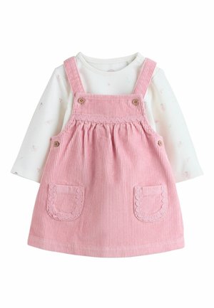 Maglietta bianca a maniche lunghe per neonati con piccoli motivi floreali sotto un vestito salopette in velluto a coste rosa con tasche frontali e bretelle con bottoni.