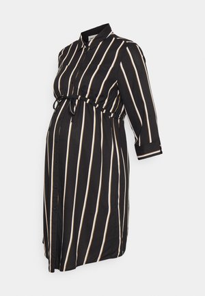 Robe de maternité noire avec des rayures verticales blanches et beige, manches longues, boutonnée à l'avant et ceinture ajustable à la taille.