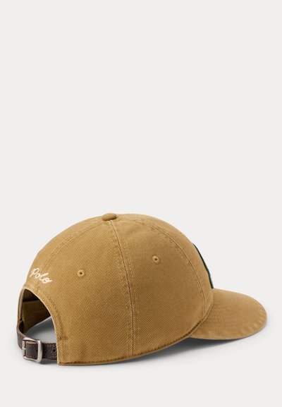Világosbarna baseball sapka, hátulján hímzett Polo logóval, állítható barna bőrszíjjal és fém csattal.