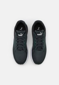 Sneaker Puma in verde scuro e nero. Presentano materiali in mesh e sintetici, lacci piatti, linguetta imbottita e suola in gomma bianca.