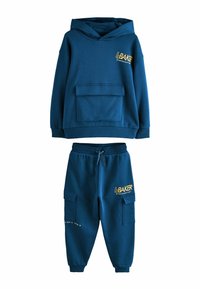 Blauwe katoenen hoodie met front pocket en gele "BAKER"-logo, gecombineerd met bijpassende joggerbroeken met zijzakken en printdetails.
