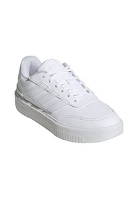 Baskets blanches avec une tige en cuir lisse et des accents texturés, des lacets plats, un col rembourré et une semelle en caoutchouc avec des rainures horizontales.