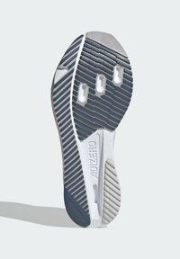 Podešev běžecké boty s běžeckým vzorkem v námořnické, šedé a bílé barvě s třemi oválnými výřezy a nápisem "ADIZERO" na mezipodešvi.