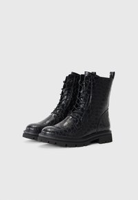 Bottines noires à lacets avec une finition texturée et brillante, présentant un motif reptilien, une semelle robuste et une languette pour un enfilage facile.