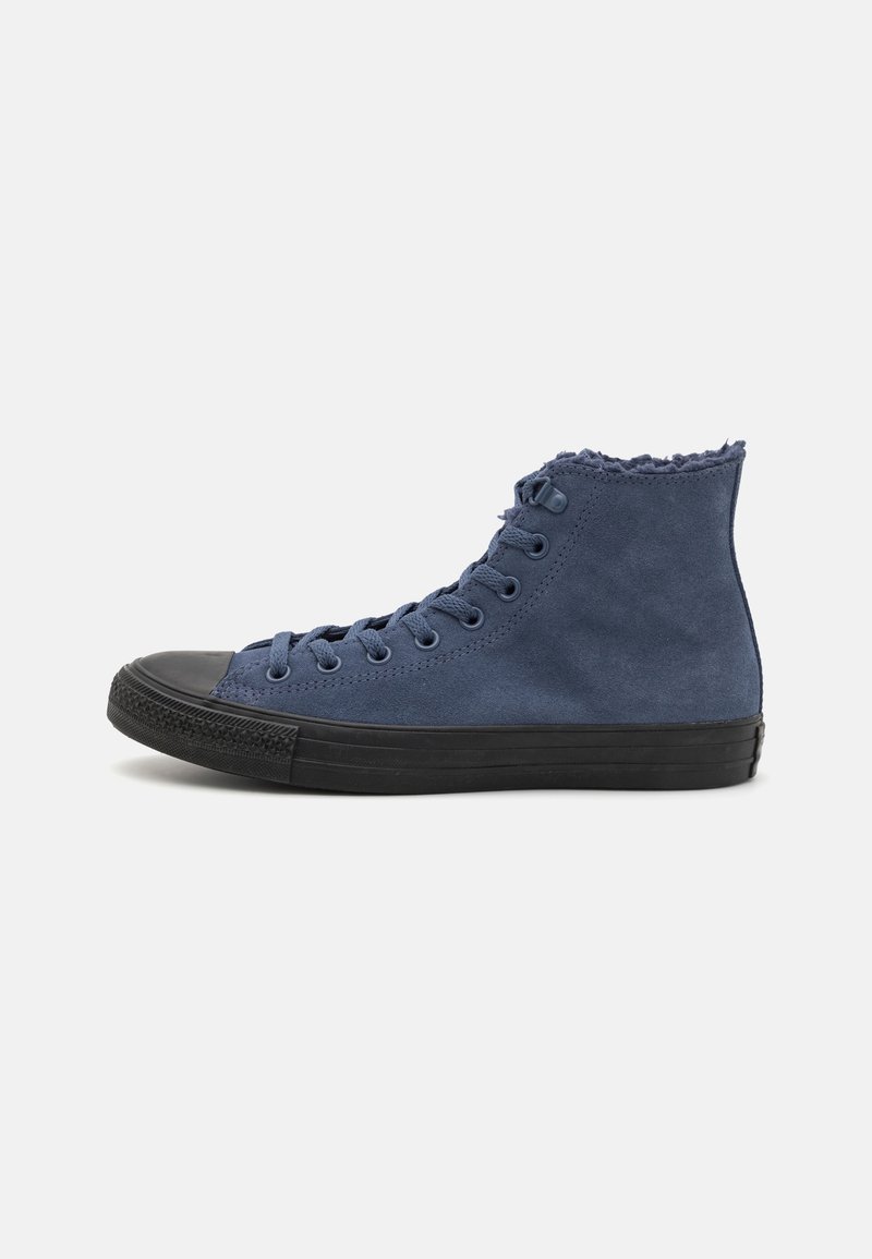 Baskets montantes en suède bleu marine avec semelle et embout en caoutchouc noir, dotées de lacets et d'une doublure intérieure douce visible à la cheville.