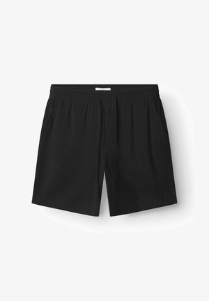 Fekete, könnyű anyagból készült sort, elasztikus derékpánttal, húzózsinórral, két oldalsó zsebbel és egyenes szabással.