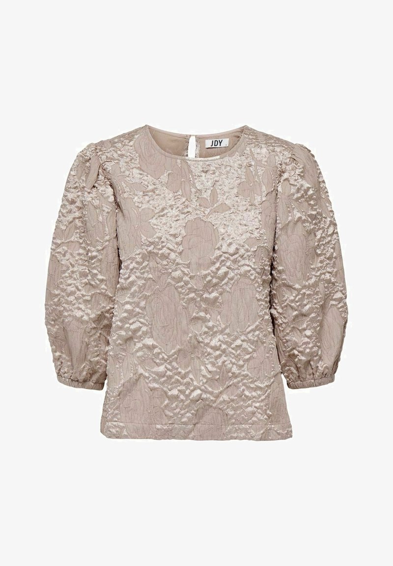 Blouse beige clair à manches longues avec motif floral texturé, col rond, manches bouffantes et poignets élastiques.