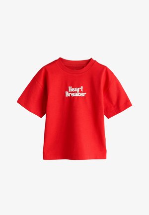 Rød T-shirt med korte ærmer og rund halsudskæring med hvid tekst "Heart Breaker" centreret på brystet.