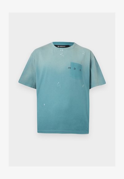 Ανοιχτό γαλάζιο T-shirt με κοντά μανίκια, μικρή τσέπη στο στήθος και τα γράμματα "mbh" τυπωμένα στην τσέπη.