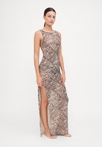 Maxi dress in tessuto leggero e trasparente caratterizzato da un motivo a strisce zebra ondulate in tonalità di marrone. Scollo alto, design senza maniche.