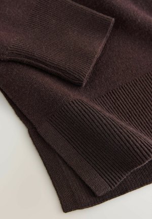 Dark brown knitted sweater featuring ribbed cuffs and hem, showcasing a textured finish with varying knit patterns throughout.