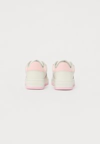 Sneakers in white and light pink colorway; leather upper with textured accents; padded collar; rubber outsole; embossed logo on heel.