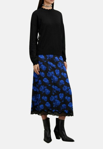Black sweater with a round neckline paired with a knee-length blue floral skirt featuring a lace hem, complemented by black ankle boots.
