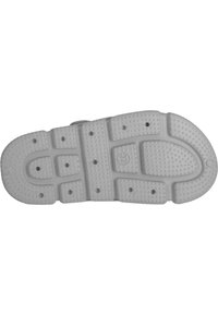 Vit gummisula med texturerade greppmönster, flera mönstringssektioner och ventilationshål. Släta kanter och rundad tådesign.