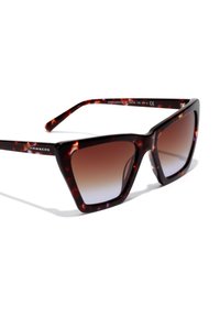 Ochelari de soare cu efect broască țestoasă, având un design geometric în formă de ochi de pisică, cu lentile degradate care se transformă de la maro închis la deschis.